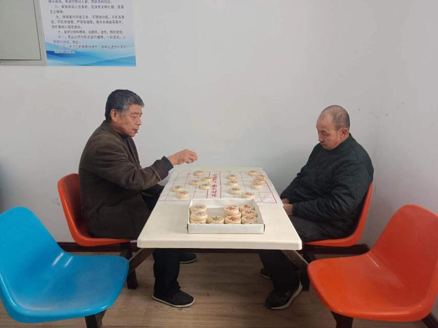 张学敬老人（图左）在涿州市中心敬老院跟新认识的朋友下象棋。李大庆摄