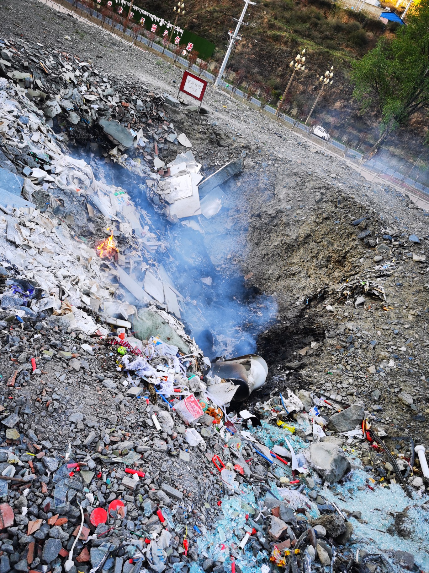 阳光新城前有一垃圾坑,有人在此焚烧垃圾,气味刺鼻,严重影响周围环境