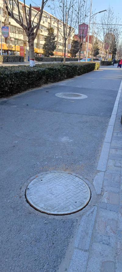 丰润区十二小区西北角的马路边井盖碎了
